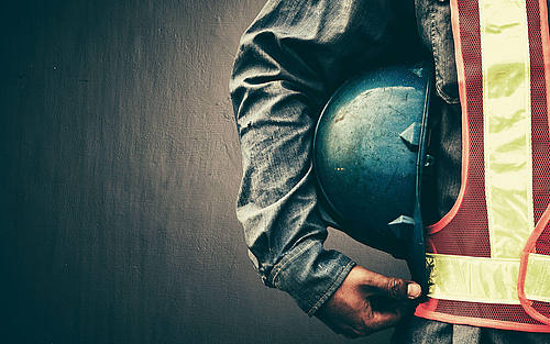 Arbeiter mit Helm unter dem Arm