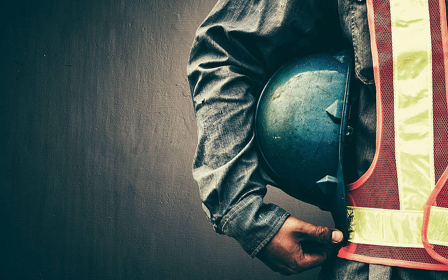 Arbeiter mit Helm unter dem Arm
