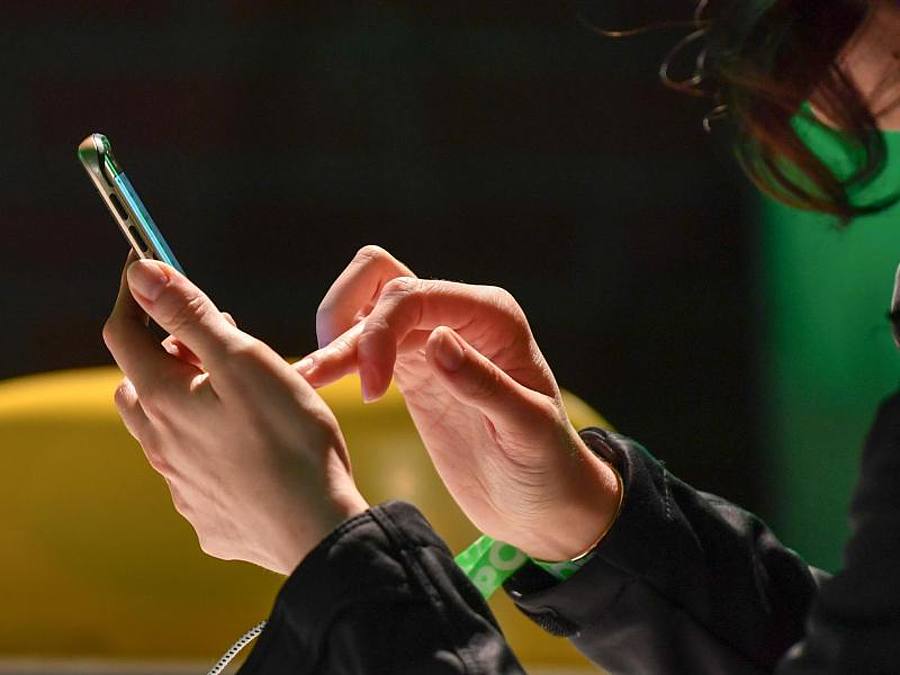 Eine Frau tippt auf ihrem Smartphone.