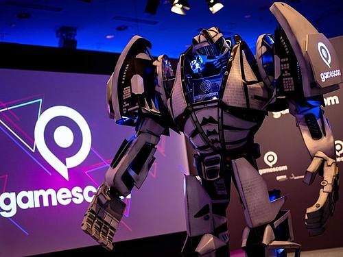 Gamesbot, das Maskottchen der Gamescom, steht während einer Pressekonferenz vor der Bühne. Foto: Marius Becker/dpa