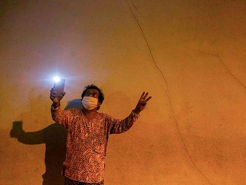 Ein Mann demonstriert in Rangun mit seinem Handy-Licht gegen den Militärputsch in Myanmar. Foto: Aung Kyaw Htet/SOPA Images via ZUMA Wire/dpa