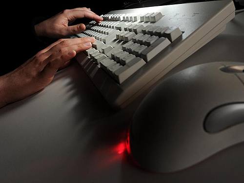 Eine Frau tippt auf einer Computertastatur. Foto: Jochen Lübke/Illustration