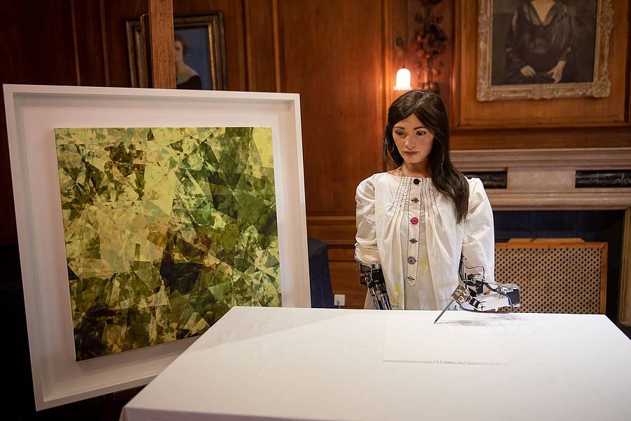 Ai-Da, die weltweit erste Roboterkünstlerin, steht während ihrer Vorstellung auf einer Pressekonferenz am Lady Margaret Hall College der Oxford University neben einem eigenen Kunstwerk.