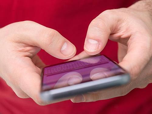 Ein Smartphone, auf dem eine Nachricht eingetippt wird. 