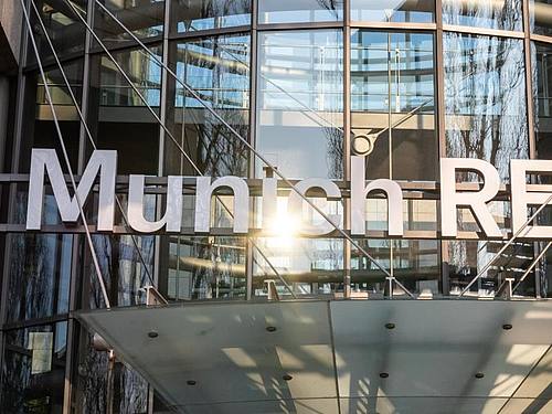 Das Logo der Munich RE am Haupteingang des Verwaltungsgebäudes der Münchener Rückversicherungs-Gesellschaft AG. Foto: Peter Kneffel/dpa