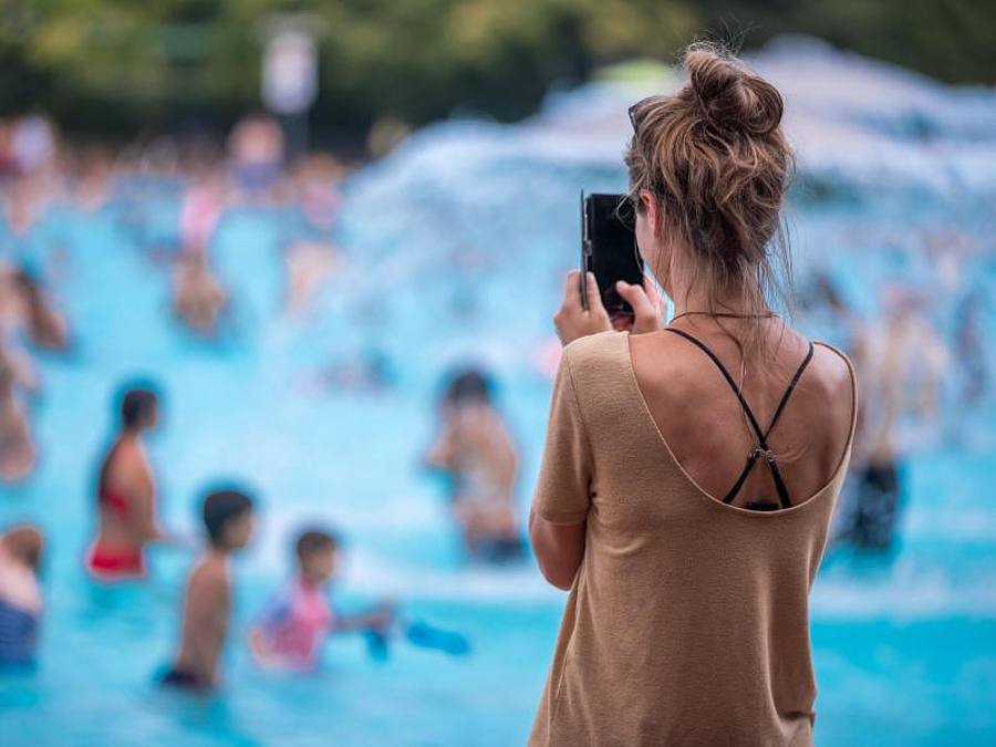 Eine junge Frau fotografiert mit ihrem Handy im Prinzenbad. Foto: Jens Büttner/ZB/dpa