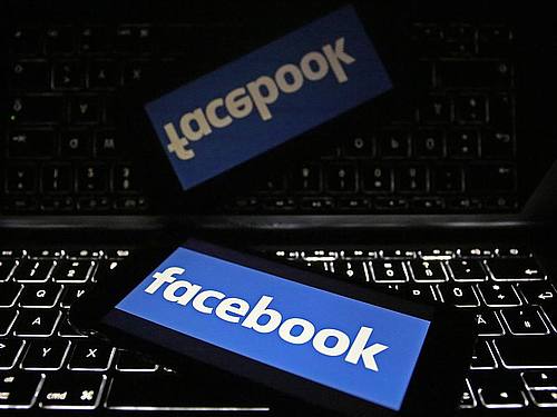 Ein Smartphone mit dem Logo von Facebook liegt auf einer Tastatur. Foto: Oliver Berg/Illustration