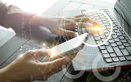 Mann nutzt Notebook und Smartphone