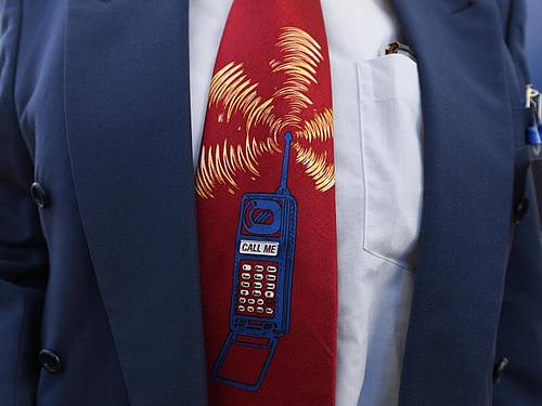 Ein Bieter trägt beim Start der Auktion von 5G-Mobilfunkfrequenzblöcken am Mainzer Technik-Standort der Bundesnetzagentur eine Krawatte mit einem Mobiltelefon. Foto: Arne Dedert