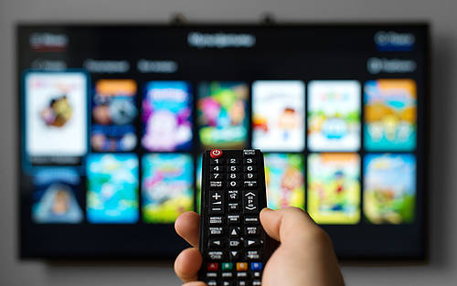 Eine Fernbedienung zeigt auf einen Smart TV