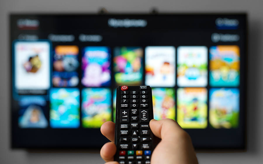 Eine Fernbedienung zeigt auf einen Smart TV