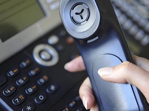 Eine Frau hält den Hörer eines Festnetz-Telefons in der Hand - der Apparat ist seit der Pandemie wieder im Kommen. Foto: Marc Müller/dpa
