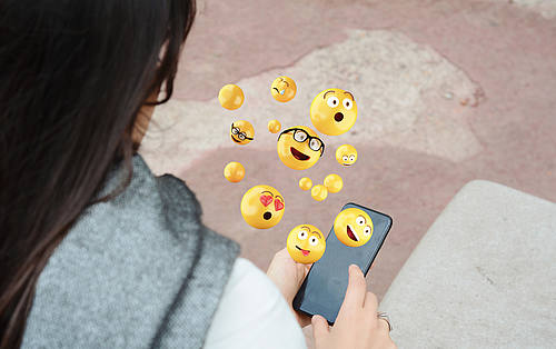 Frau mit Smartphone aus dem Emojis kommen
