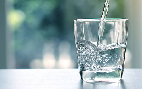 Glas mit Wasser steht auf einem Tisch