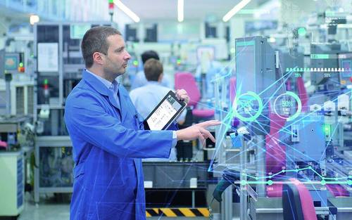 Mitarbeiter mit Tablet vor Werkzeugmaschine