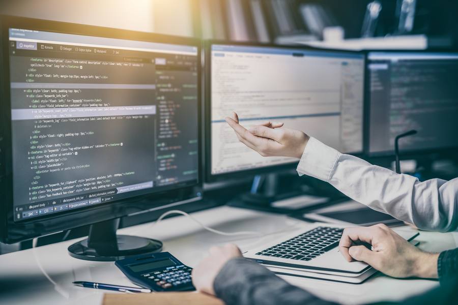 IT-Fachkräfte diskutieren vor Monitor