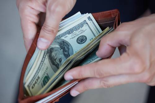 Hände öffnen Geldbörse mit Dollarscheinen