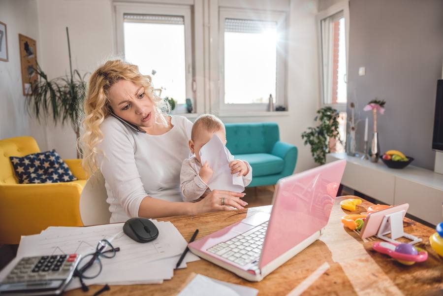 Mutter mit Kleinkind im Homeoffice