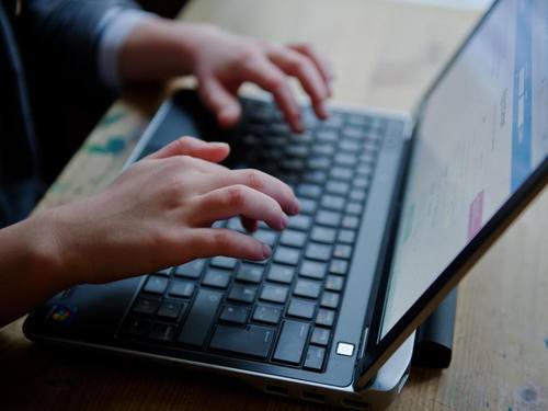 Ein junges Mädchen sitzt an einem Laptop. Kinder sollen besser vor sogenanntem «Cybergrooming» geschützt werden. Foto: Nicolas Armer