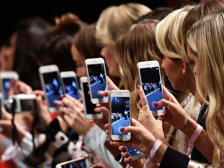 Frauen mit Smartphones filmen und fotografieren auf der Berlin Fashion Week. Foto: Jens Kalaene
