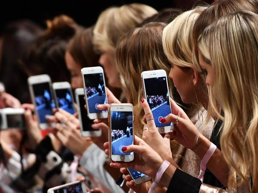 Frauen mit Smartphones bei der Fashion Week in Berlin. Experten zufolge ist der Markt für Computerhandys gestättigt. Foto: Jens Kalaene
