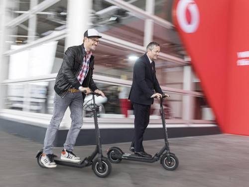 Vodafone-Chef Hannes Ametsreiter (r) und der Chef der Walberg Urban Electrics Florian Walberg (l) mit ihren elektrisch angetriebenen Tretrollern auf der Cebit. Foto: Nils Hendrik Mueller