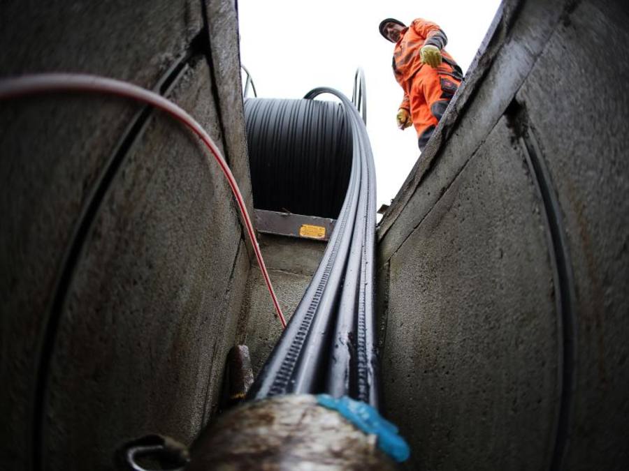Arbeiter verlegen Glasfaserkabel. In gut eineinhalb Jahren soll bundesweit für jeden Haushalt ein Anschluss mit einem Surftempo von mindestens 50 MBit pro Sekunde verfügbar gemacht werden. Foto: Oliver Berg