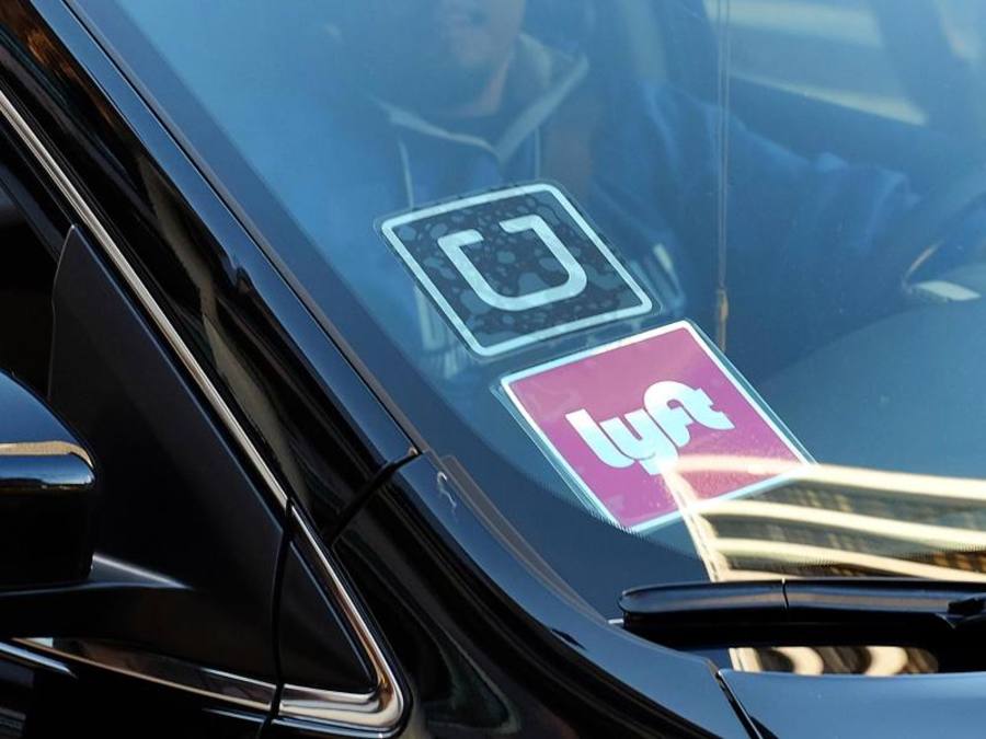 An der Scheibe eines Autos hängen Aufkleber der beiden Fahrdienst-Vermittler «Uber» und «Lyft». Foto: Richard Vogel/Archiv