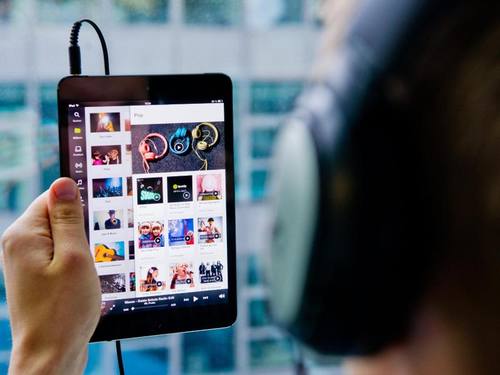 Ein Mann hört in Berlin mit einem Ipad Musik. Foto: Daniel Bockwoldt/Illustration