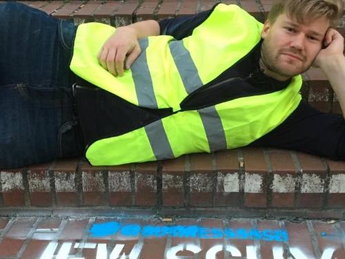 Der Berliner Künstler Shahak Shapira liegt vor dem mit Farbe auf den Boden gesprühtem Wort «Jew Scum». Foto: Shahak Shapira