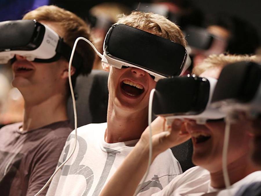 Besucher der Gamescom in Köln geniessen mit einer Virtual Reality-Brille eine Achterbahnfahrt. Foto: Oliver Berg