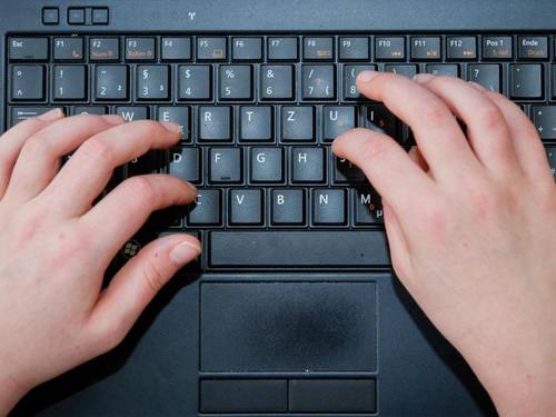 Die Hände eines Kindes an der Tastatur eines Laptops. Foto: Ole Spata