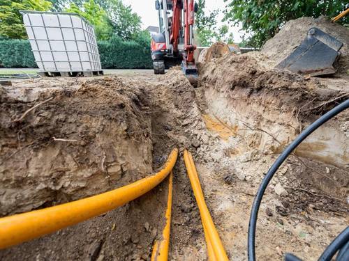 Ein Bagger hebt Erdreich für die Verlegung von Breitband-Kabeln aus. Foto: Guido Kirchner