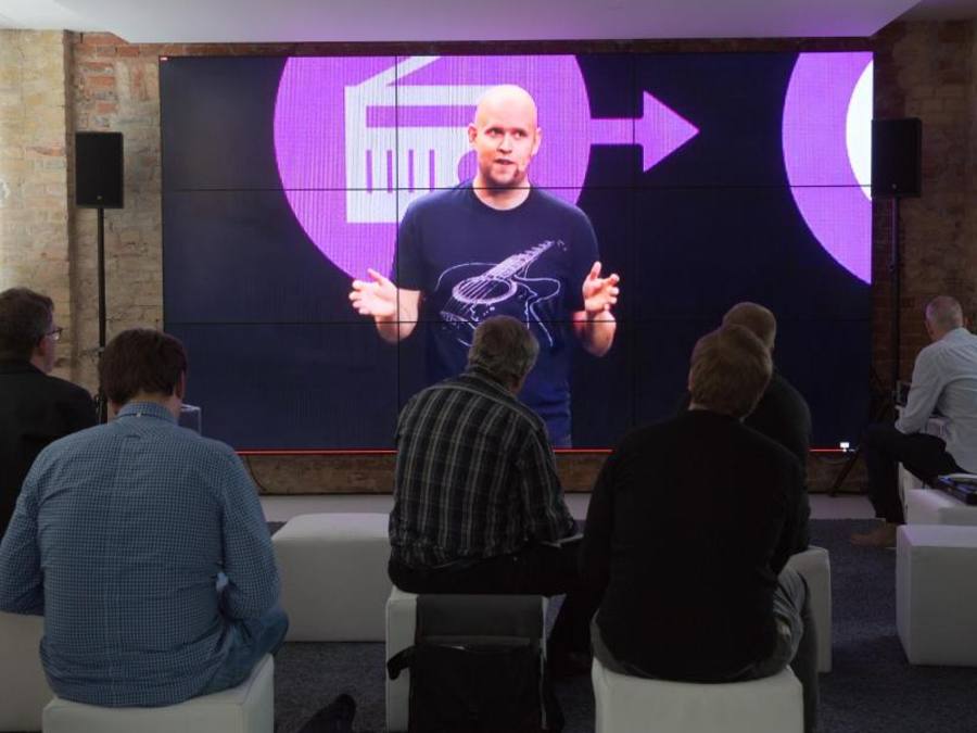 Spotify-Chef Daniel Ek ist durch einen Live-Stream auf einem Bildschirm bei einer Presse-Veranstaltung in Berlin zu sehen. ((Foto: Jörg Carstensen/Archiv))