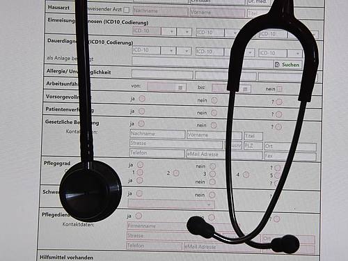 In einem Behandlungszimmer einer Praxis hängt ein Stethoskop vor einer auf einem Bildschirm dargestellten elektronischen Patientenakte (ePA). Foto: Stefan Sauer/ZB/dpa