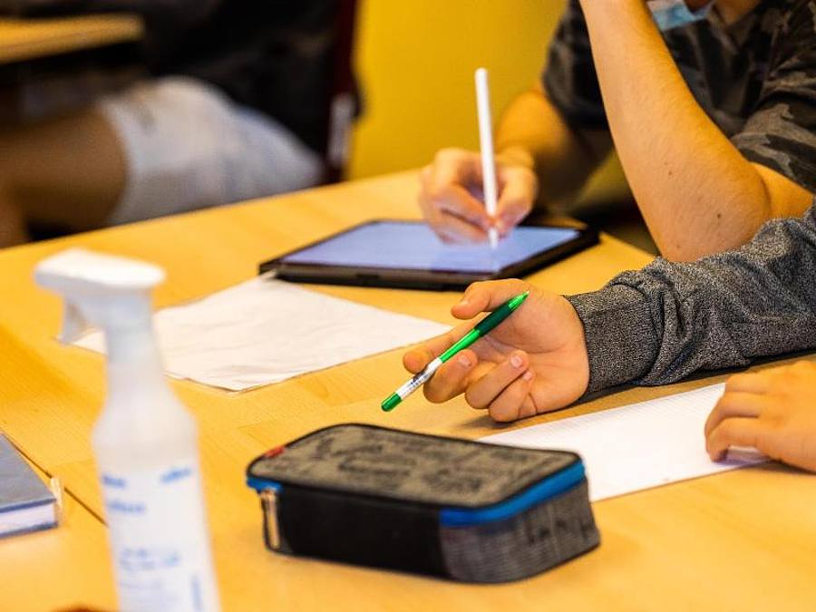 Ein Schüler hält beim Unterricht in seiner Klasse einen Stift, während ein anderer mit einem Tablet arbeitet. Foto: Philipp von Ditfurth/dpa