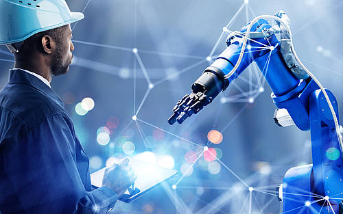 Bauarbeiter steuert Roboterarm mit Tablet
