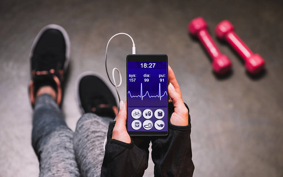 Sportliche Frau mit Fitness-App