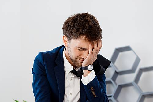 Verärgerter junger Geschäftsmann am Arbeitsplatz