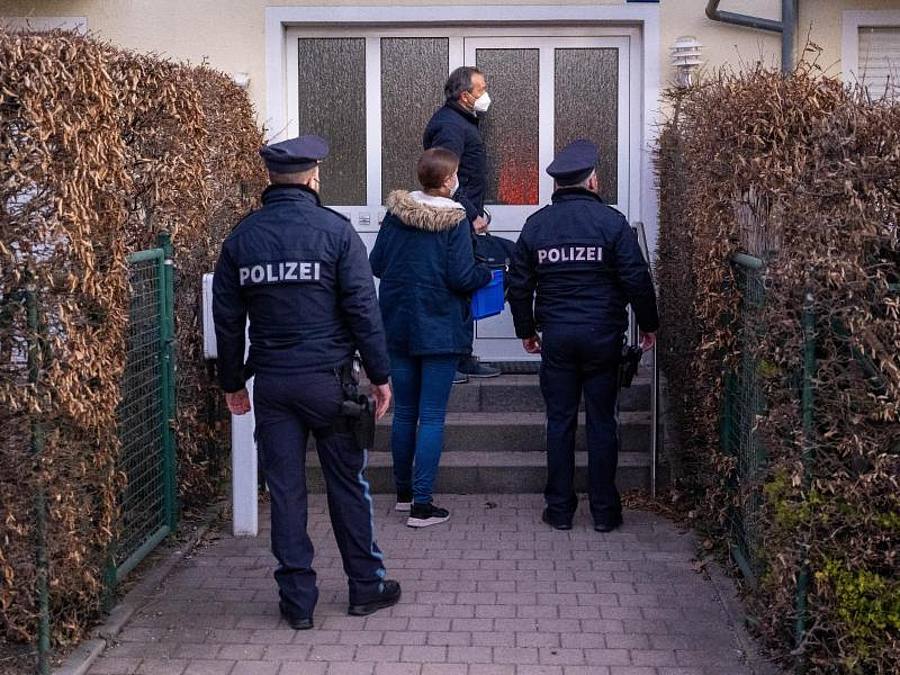 Die Polizei steht vor einem Haus eines Verdächtigen in München. Foto: Peter Kneffel/dpa