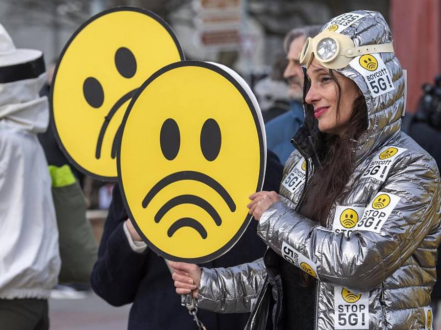 Menschen nehmen an einem weltweiten Protesttag gegen die fünfte Mobilfunkgeneration (5G) mit ultraschnellen Datenverbindungen auf dem Genfer Place des Nations teil. Foto: Martial Trezzini/KEYSTONE/dpa