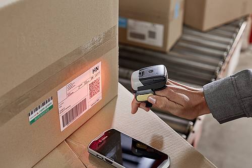 Handheld-Scanner von Zebra liest Paketetikett aus.