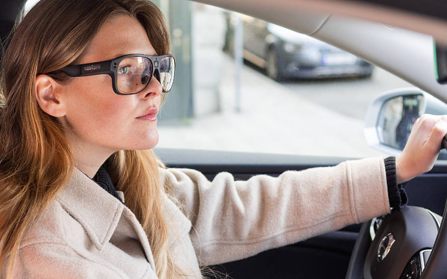 Frau fährt Auto mit Tracking-Brille