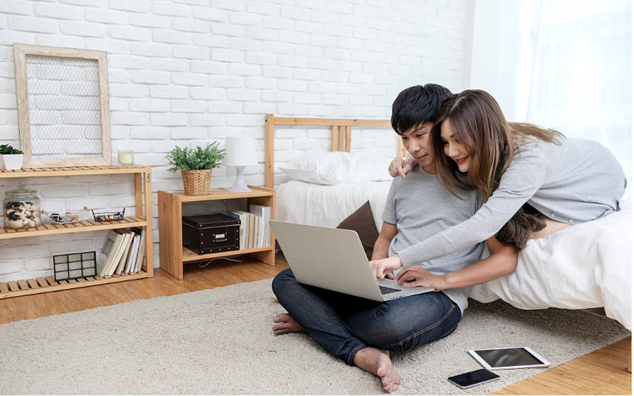 Asiatisches Paar schaut auf Laptop