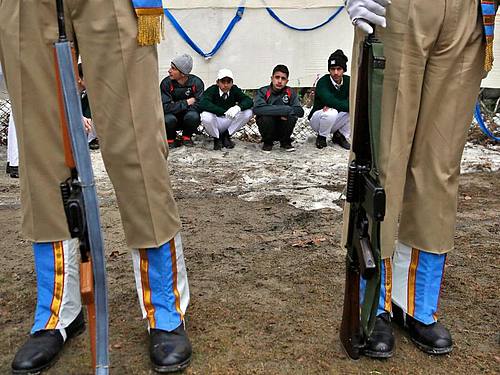 Indische Soldaten vor Schülern aus Kaschmir während einer Parade zum indischen Nationalfeiertag. Foto: Mukhtar Khan/AP/dpa