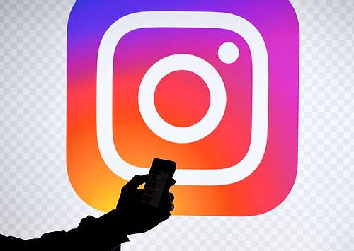 Ein Smartphone vor dem Logo von Instagram.