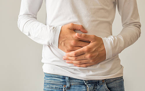 Mann hält sich den Bauch