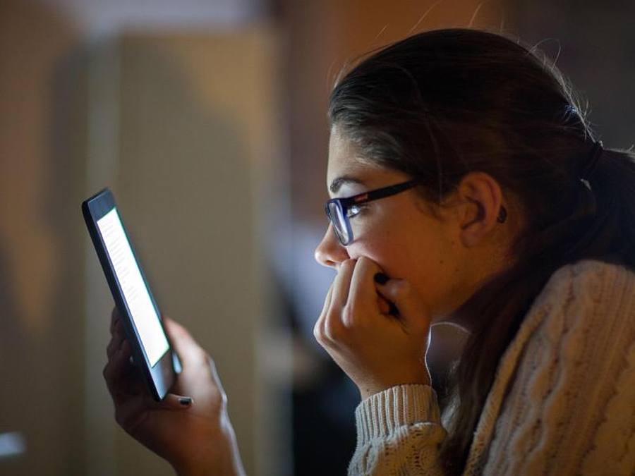 Eine Frau liest auf einem digitalen Lesegerät ein E-Book. Foto: Jens Büttner