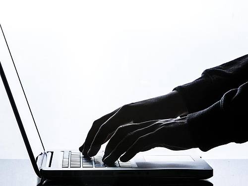 Hand am Laptop, schwarz-weiß. Foto: Silas Stein/dpa/Illustration