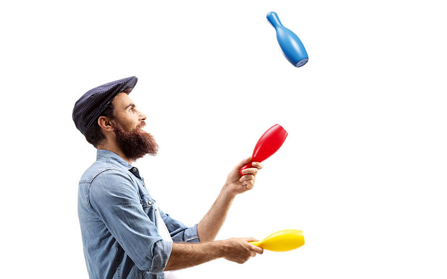 Jongleur mit Keulen auf Einrad